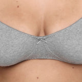 Close-up of a person wearing a light gray bra, showing the center and fabric texture.
