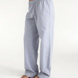 Person wearing blue checkered pajama pants on a white background