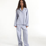 Woman wearing a blue checkered pajama set on a white background
