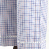 Blue and white checkered curtain with lace trim on a wooden rod.