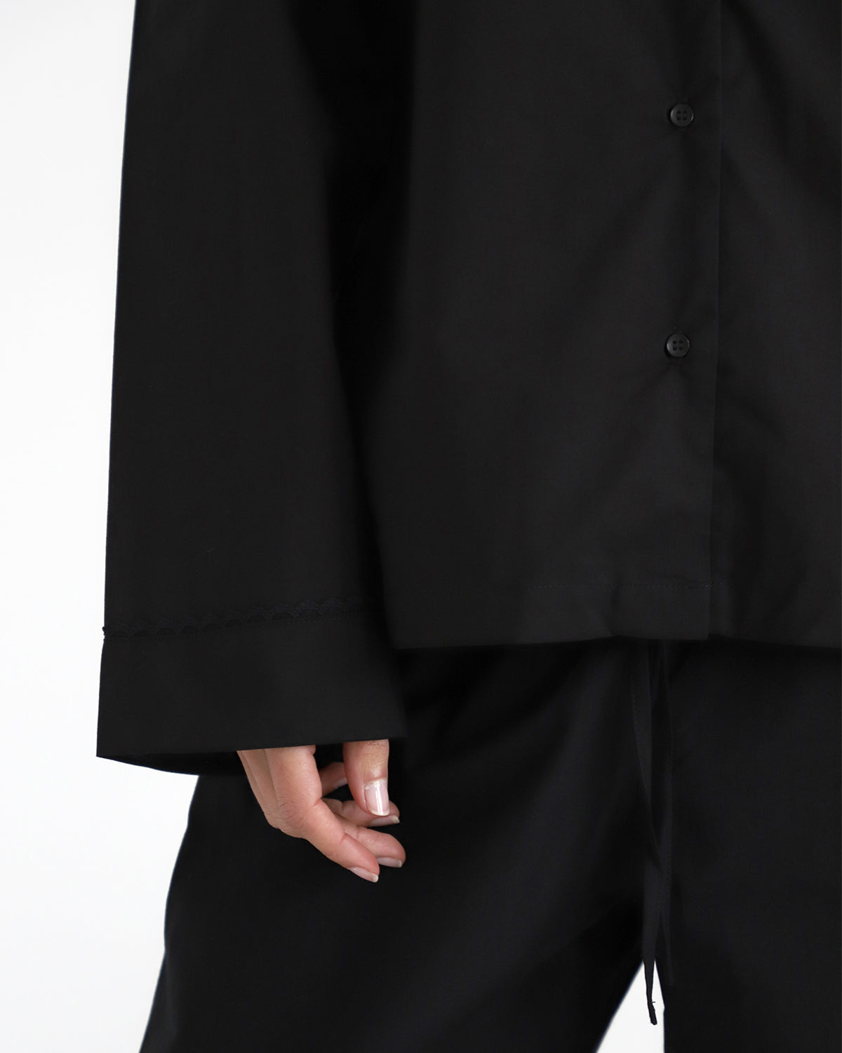 Close-up of a black shirt and pants on a white background