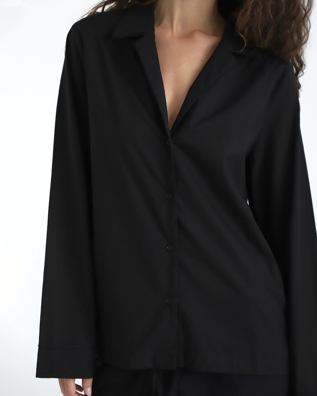 Black shirt worn by a person on a white background