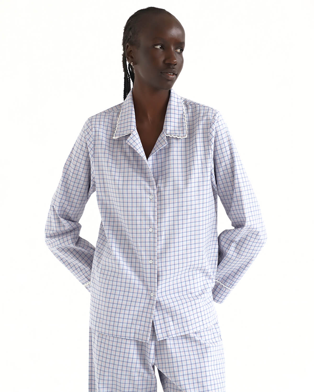 Person wearing a checkered pajama set on a white background