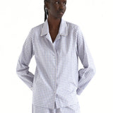 Person wearing a checkered pajama set on a white background