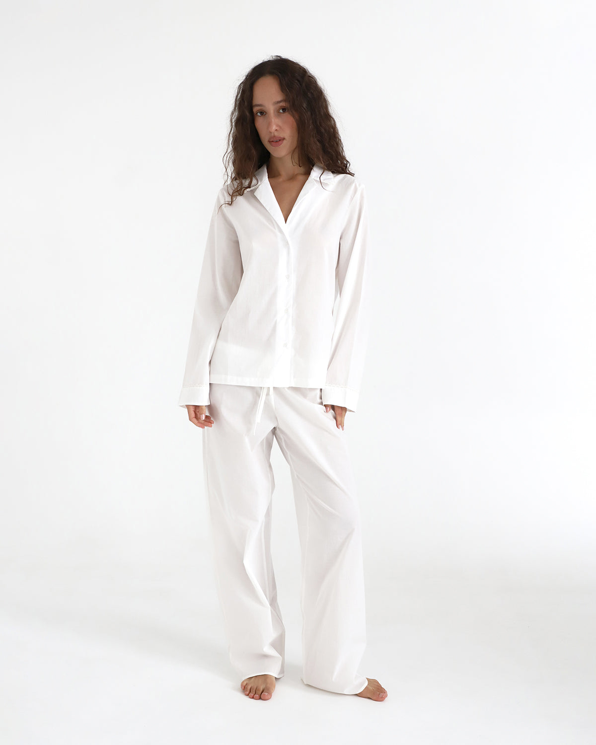 Woman wearing a white pajama set on a white background