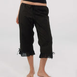 Black capri pants with ruffled hem on a white background