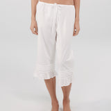 White capri pants worn by a person on a white background
