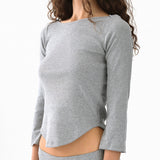 Gray long-sleeve top worn by a person on a white background