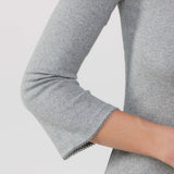 Gray long-sleeve top with a close-up of the sleeve on a light gray background