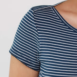 Close-up of a person wearing a short-sleeve top with navy blue and white horizontal stripes, showing the shoulder, sleeve, and side neckline against a plain light background.