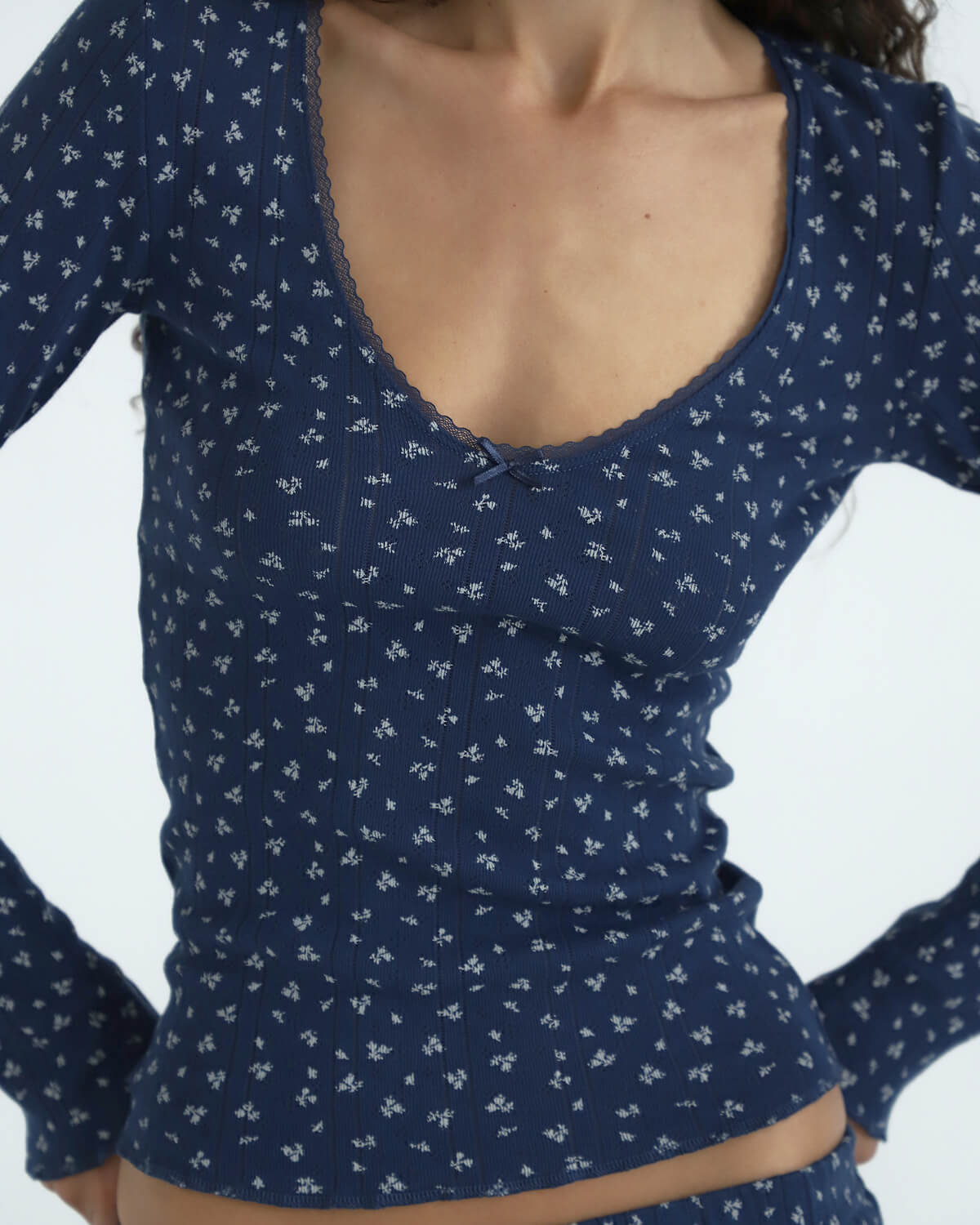 Navy blue long-sleeve top with white floral pattern on a plain background