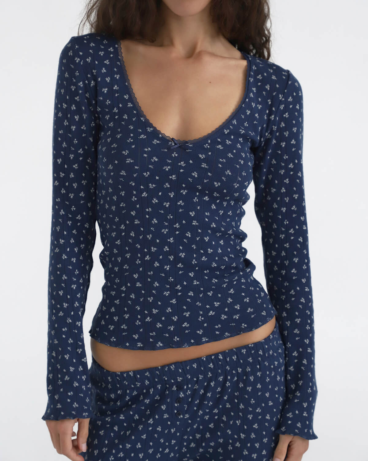 Navy blue long-sleeve top with white pattern on a plain background