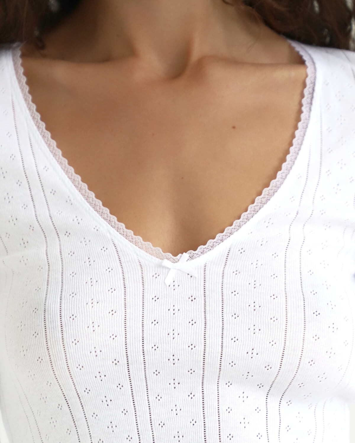Close-up of a white lace-trimmed top on a blurred background