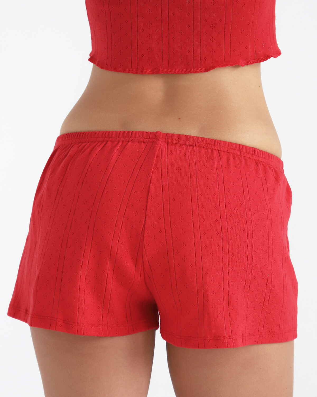 Red shorts worn by a person on a white background