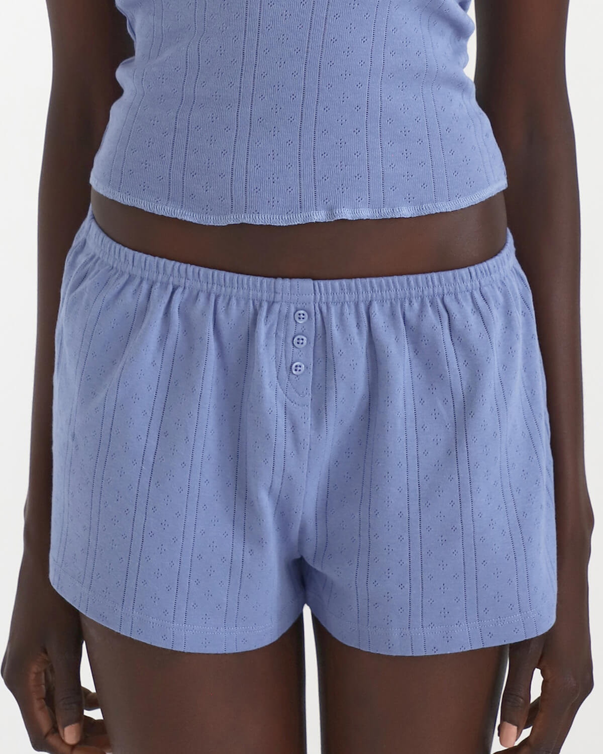 Blue textured shorts worn by a person on a white background