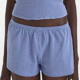 Blue textured shorts worn by a person on a white background