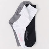 Three pairs of socks in gray, white, and black on a light gray background