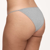 A close-up rear view of a model wearing a light gray underwear against a plain off-white background.