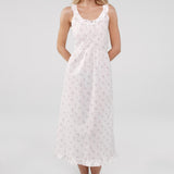 Woman wearing a white lace dress against a plain background