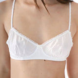 White bra with lace details on a plain background