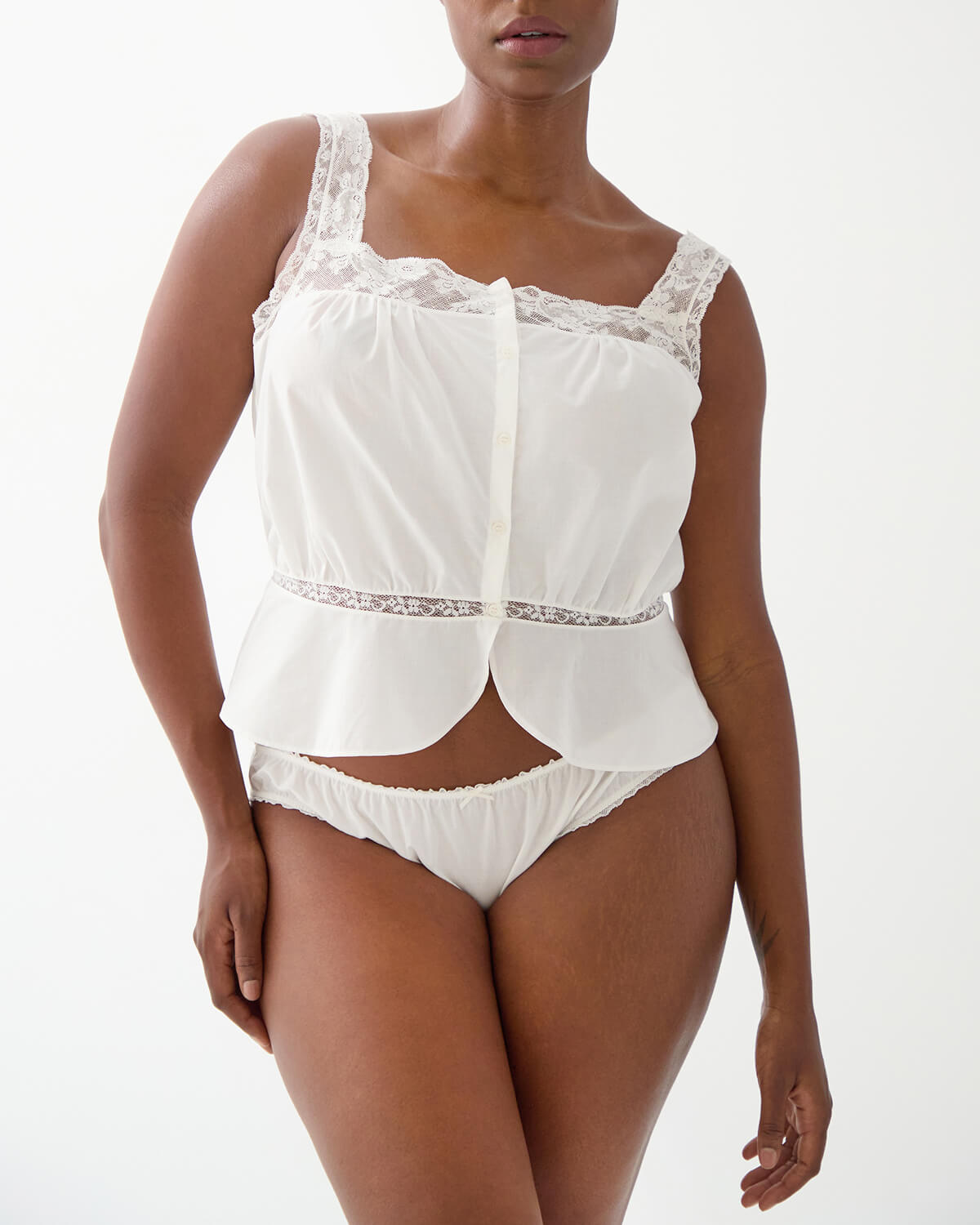 Woman wearing a white lace top and underwear set on a white background