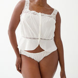 Woman wearing a white lace top and underwear set on a white background