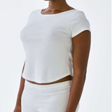Person wearing a white crop top and shorts on a plain background