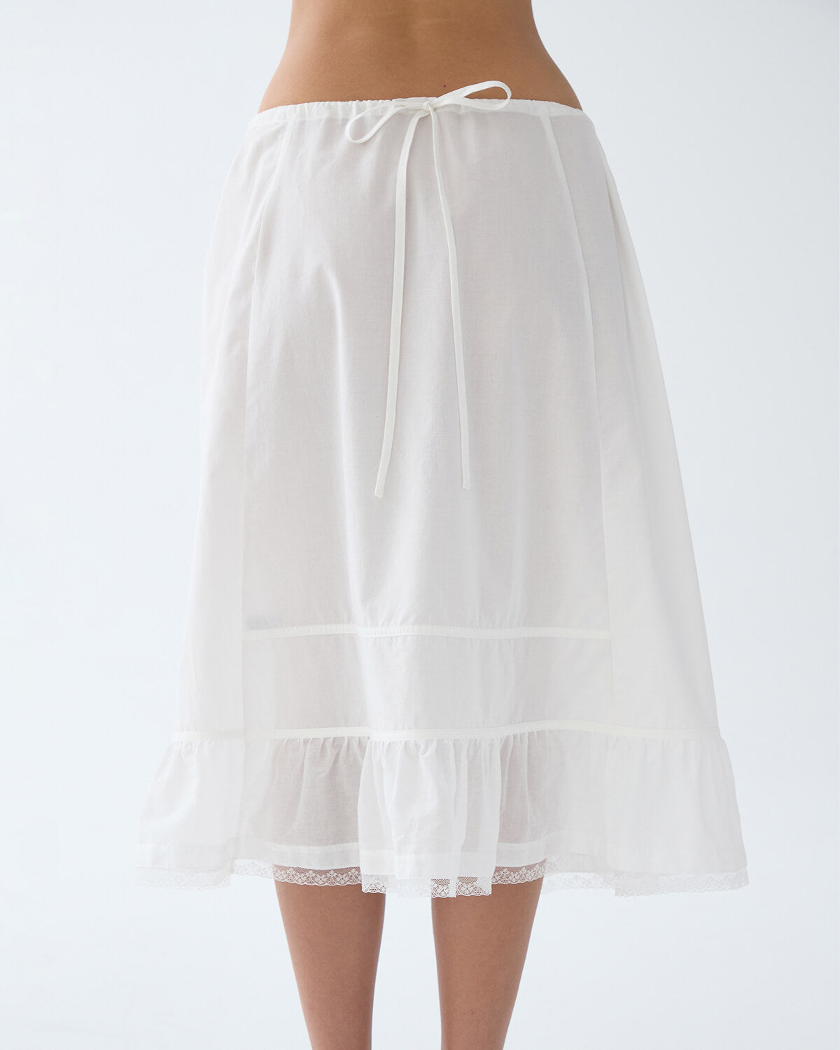 White petticoat worn by a person on a white background