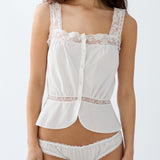 Woman wearing a white lace lingerie set on a plain background